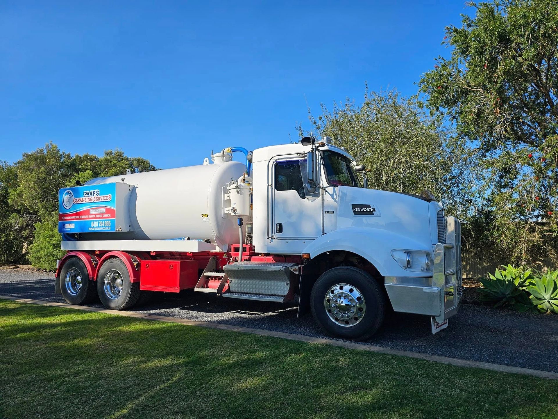 White Septic Tank Truck Parked on Green Grass, Blue Sky Background — Paap's Cleansing Services in Woodgate, QLD