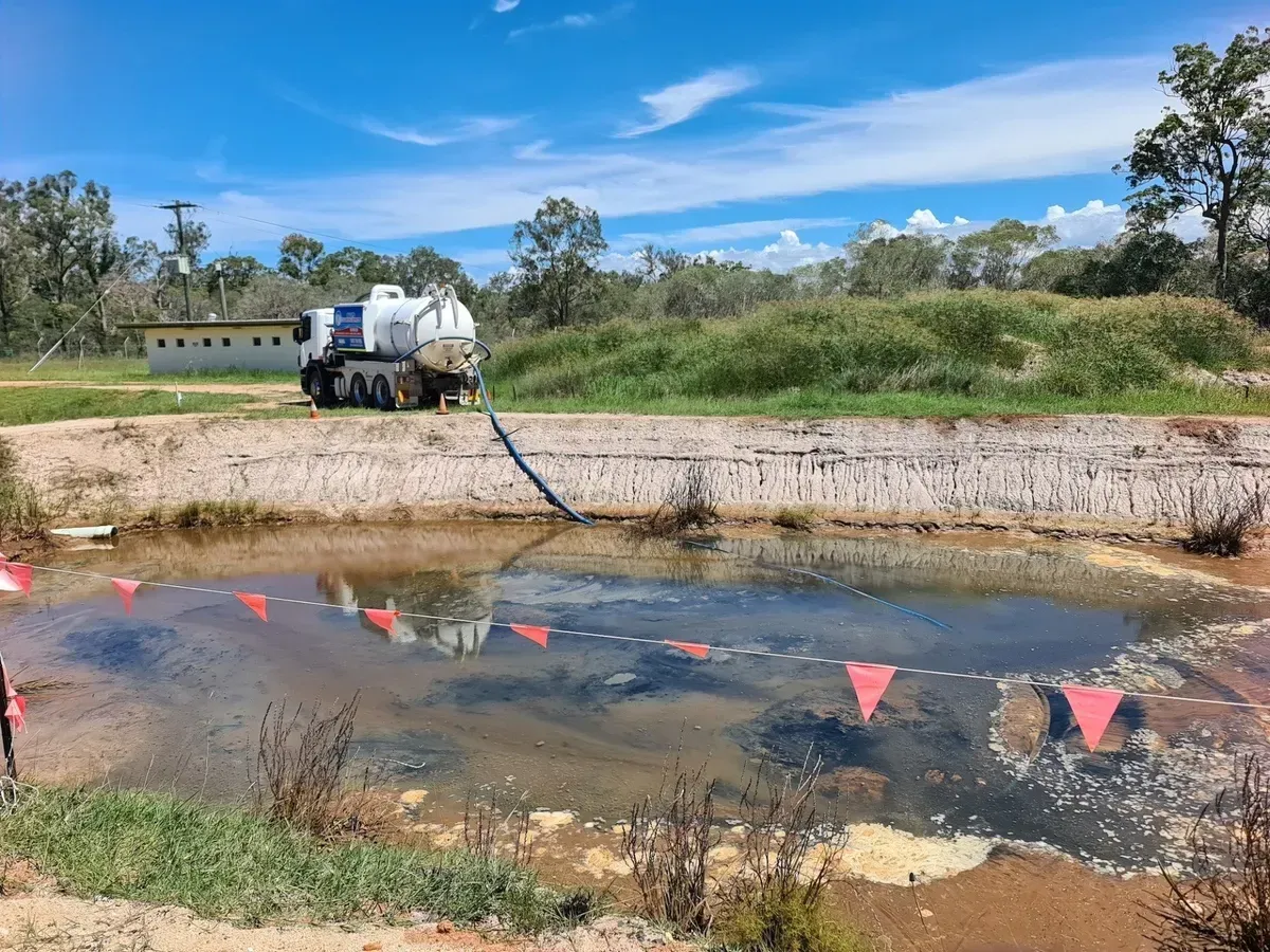 A Truck Pumping Liquid From a Murky Pond — Paap's Cleansing Services in Branyan, QLD