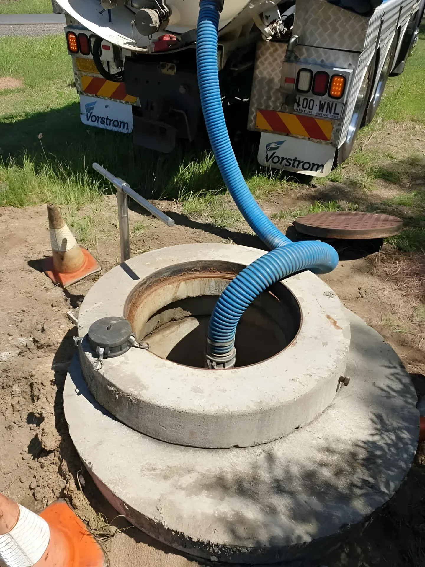 Blue Hose Pumping Out a Concrete Manhole — Paap's Cleansing Services in Burrum Heads, QLD
