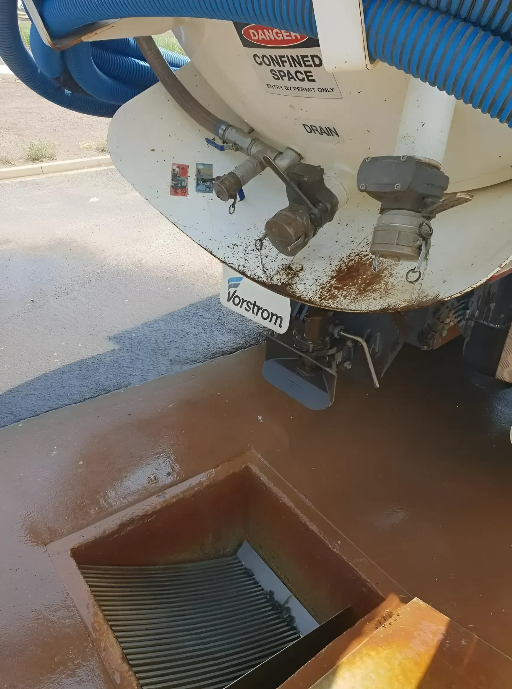 A Wastewater Truck Discharging Into a Brown Drainage Grate — Paap's Cleansing Services in Gin Gin, QLD
