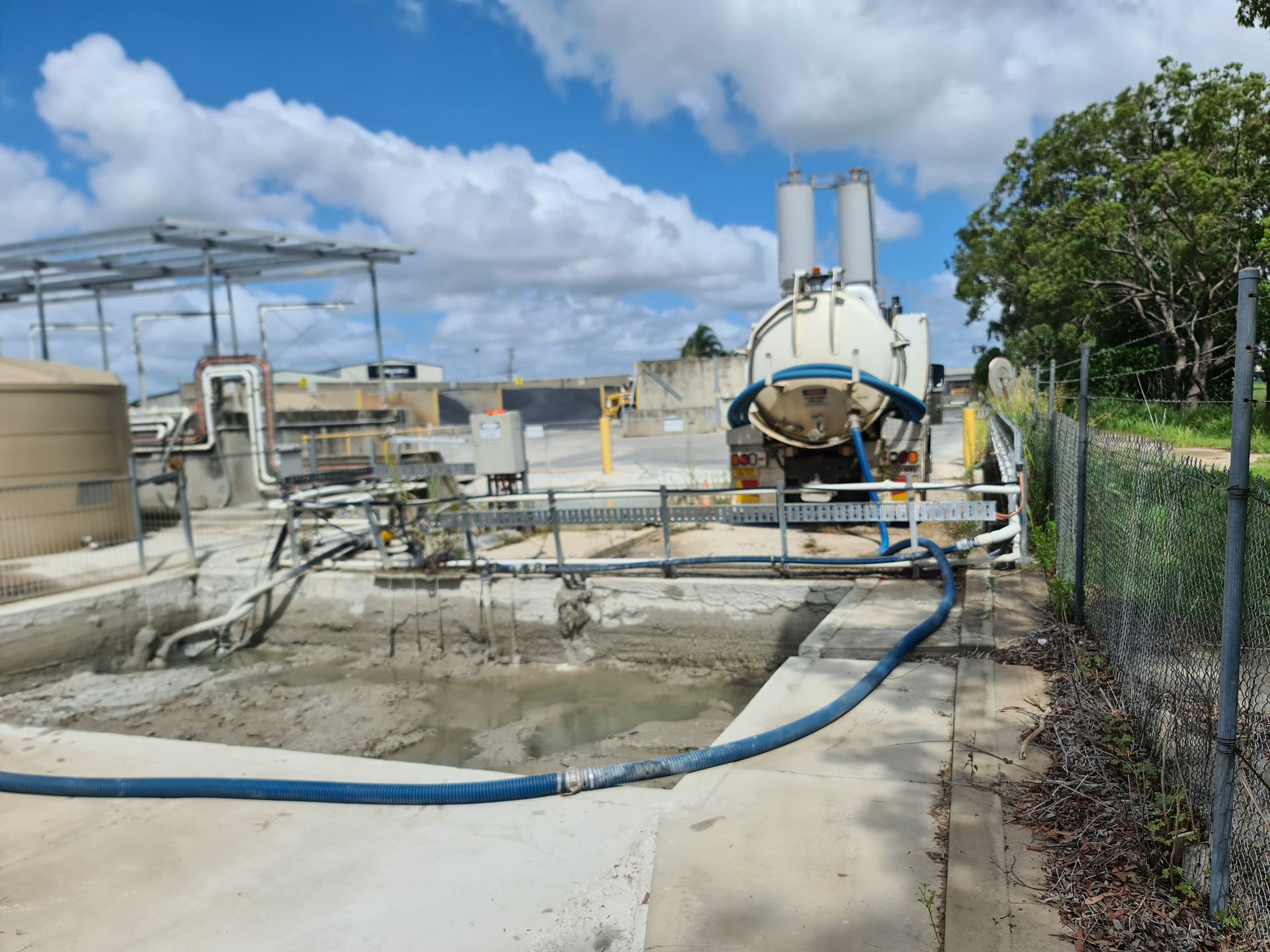 A Vacuum Truck Pumps Sludge From a Concrete Basin — Paap's Cleansing Services in Branyan, QLD