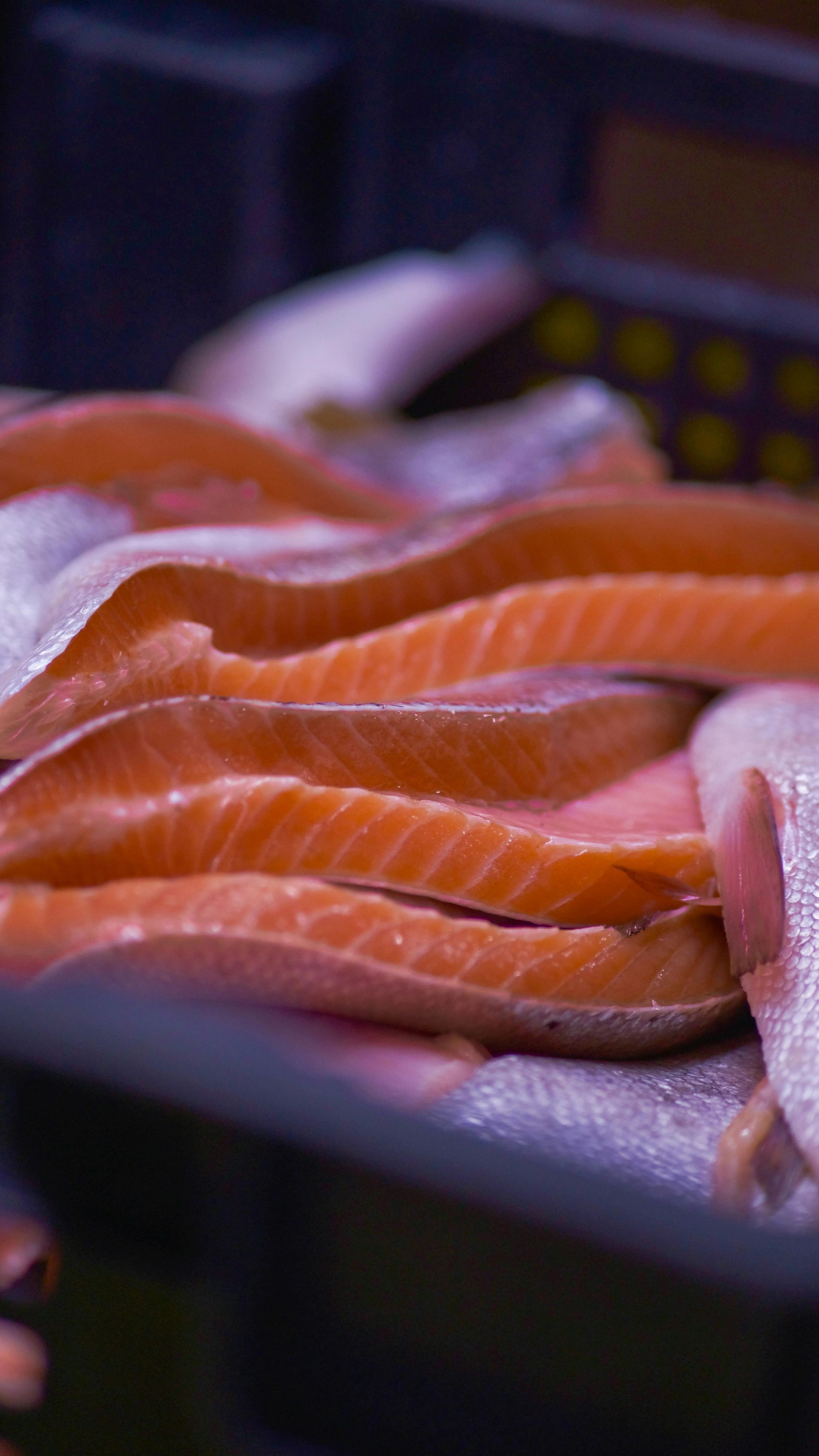 A close up of sliced salmon in a tray.