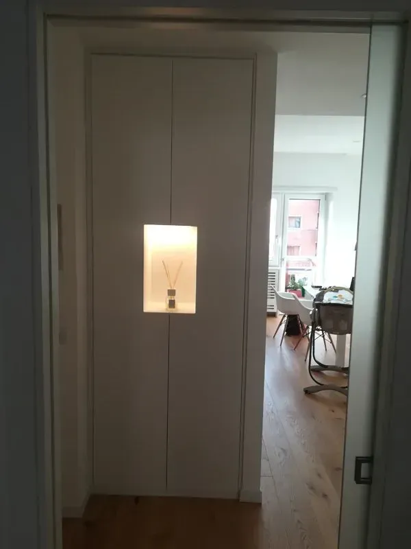 Un corridoio con una porta a vetri che conduce al soggiorno.