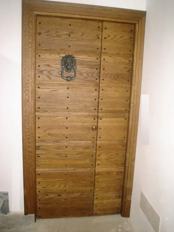 Una porta di legno con un batacchio a forma di leone