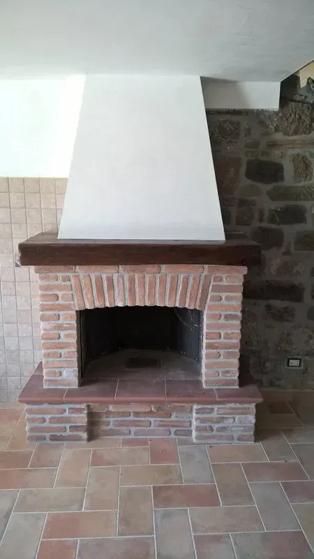 C'è un camino in mattoni al centro della stanza.