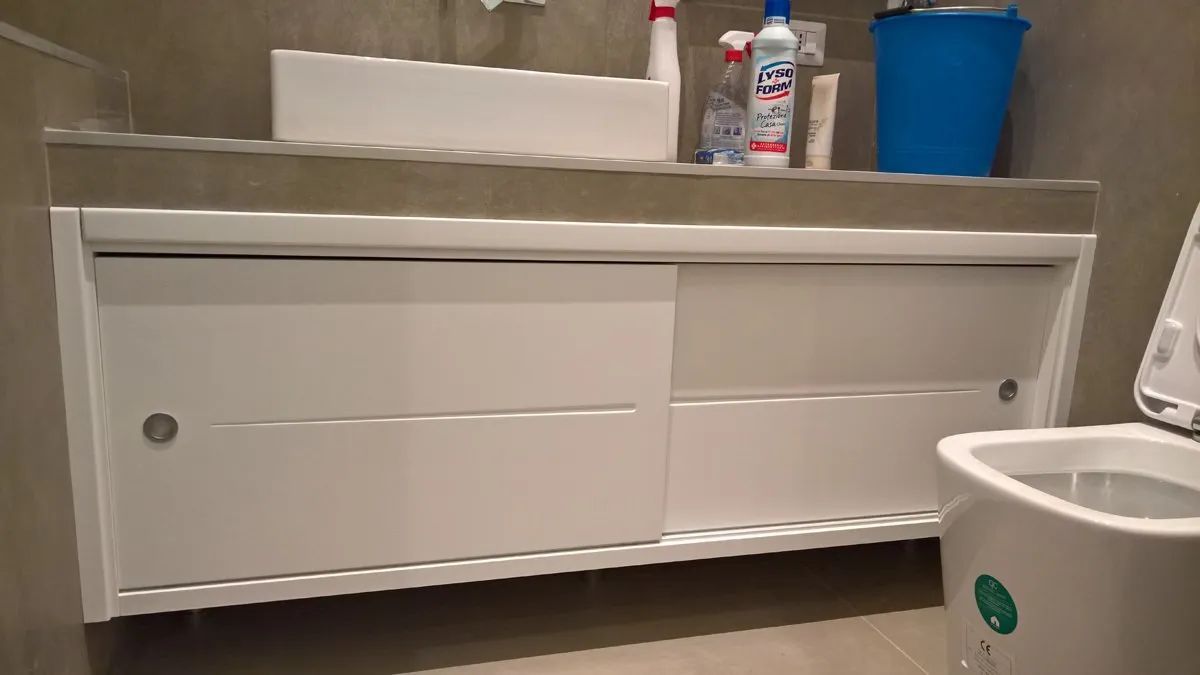 Un bagno con lavandino, water e cestino dei rifiuti.