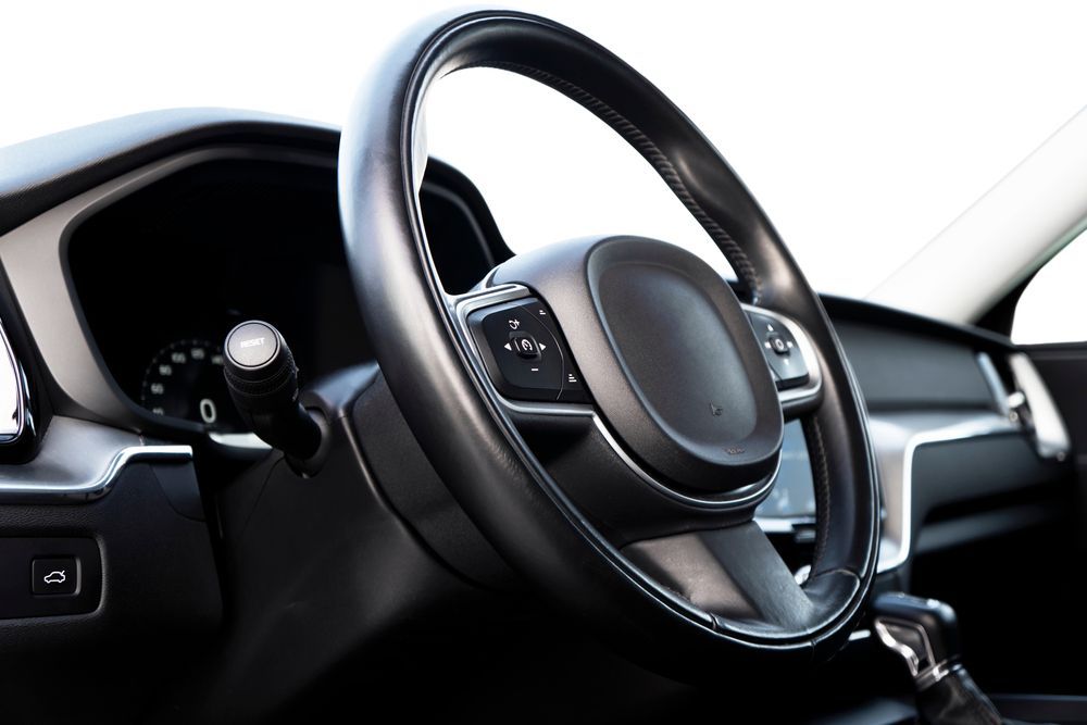 A Black Steering Wheel in A Car Interior with Dashboard and Side Panel — Hervey Bay Brake and Exhaust in Pialba, QLD