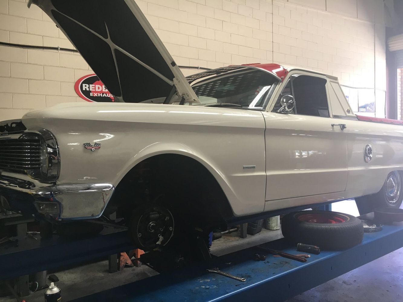 A Vintage Car on A Lift, Hood Open, Inside a Garage — Hervey Bay Brake and Exhaust in Pialba, QLD