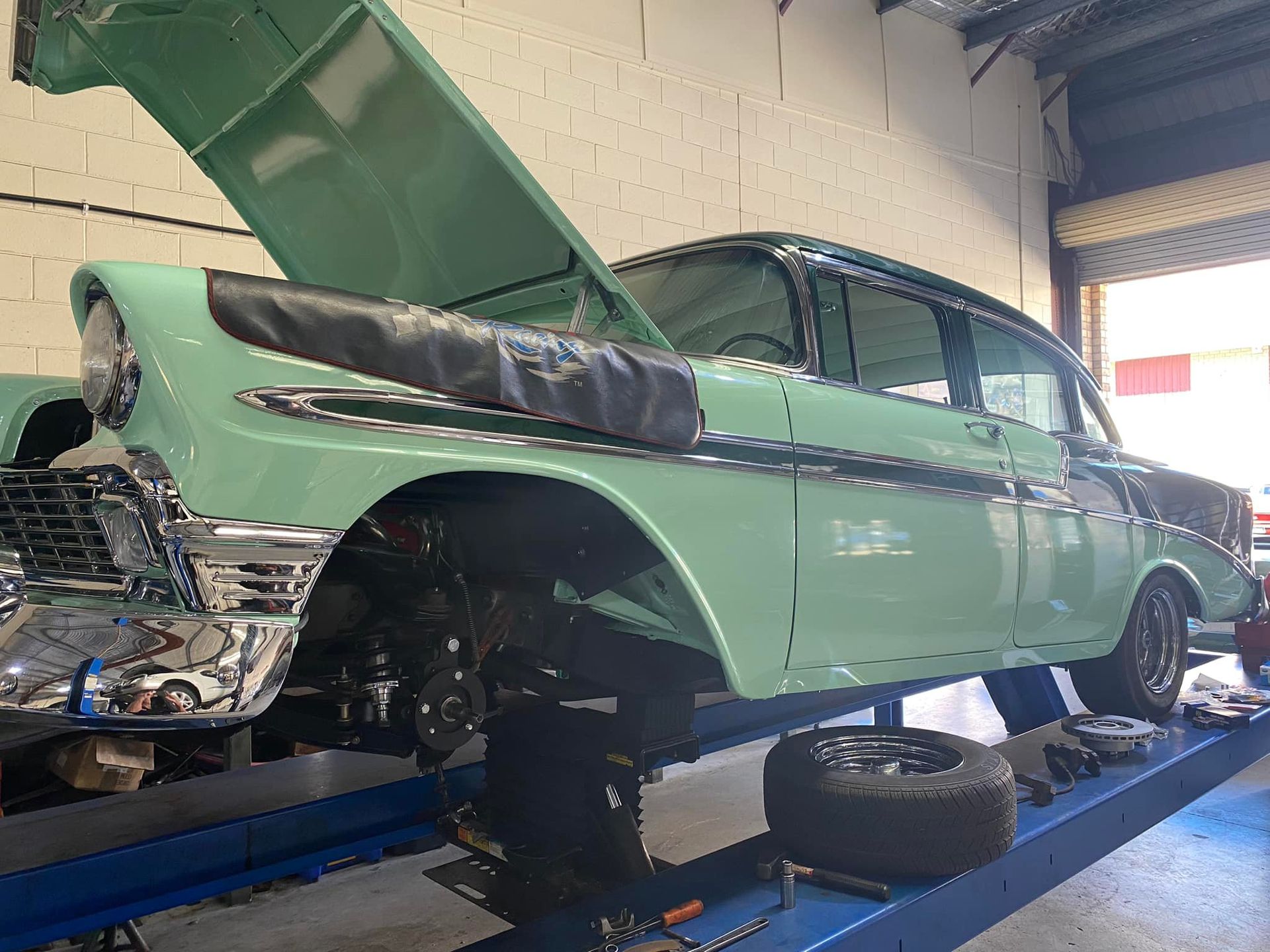 A Mint Green Classic Car Raised on A Lift in A Garage — Hervey Bay Brake and Exhaust in Pialba, QLD
