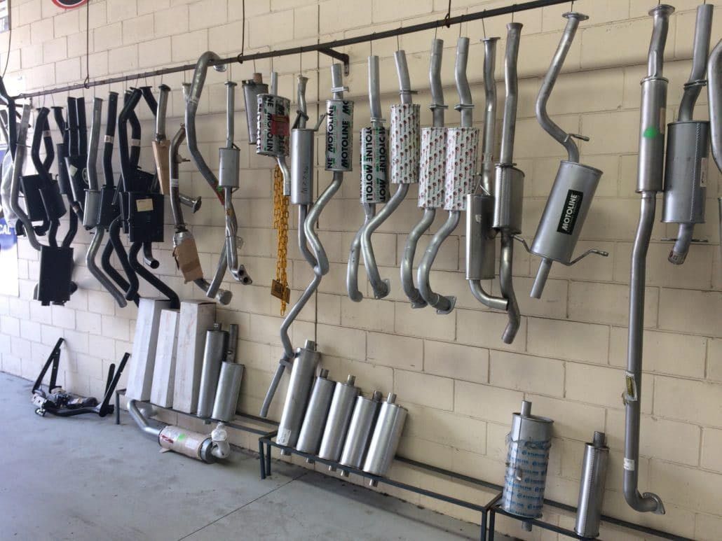 An Exhaust Pipes of Various Shapes and Sizes Hanging on A Wall — Hervey Bay Brake and Exhaust in Pialba, QLD