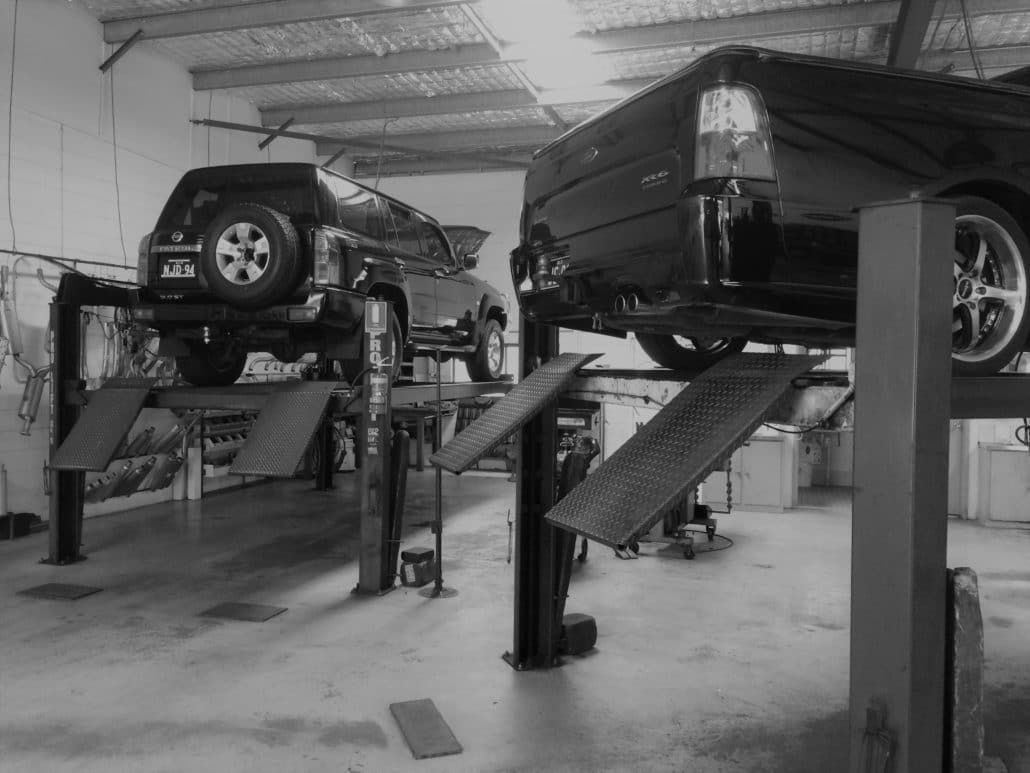 Two Vehicles on Hydraulic Lifts Inside a Garage — Hervey Bay Brake and Exhaust in Pialba, QLD