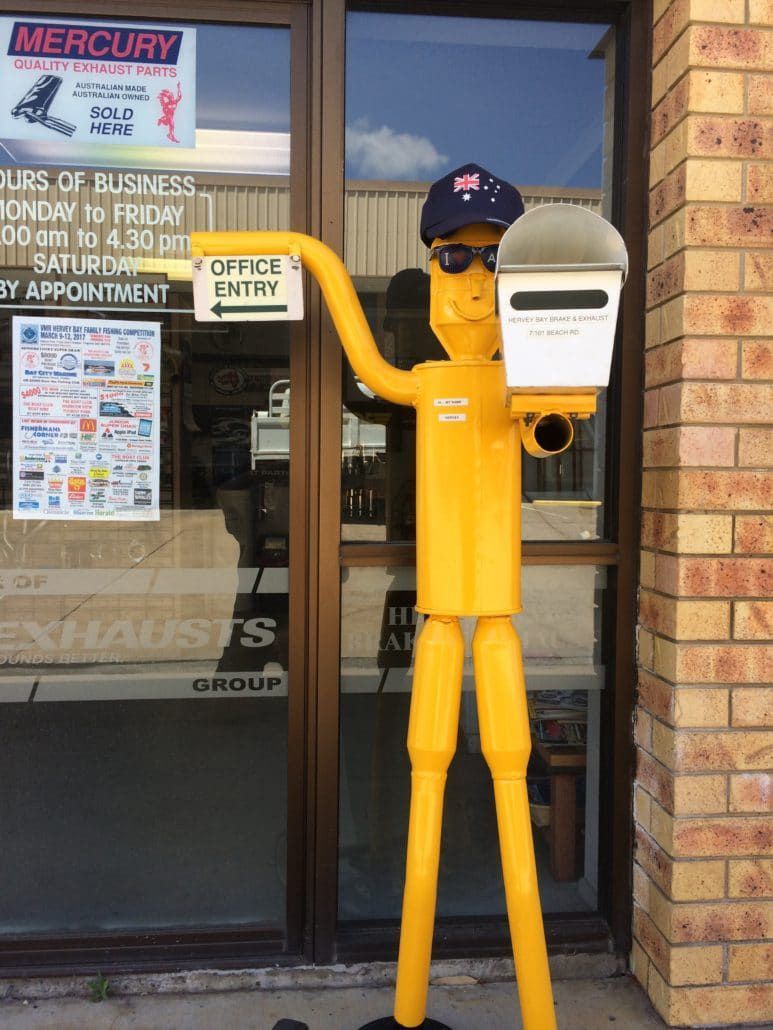 A Yellow Metal Figure Holding a Mailbox — Hervey Bay Brake and Exhaust in Pialba, QLD