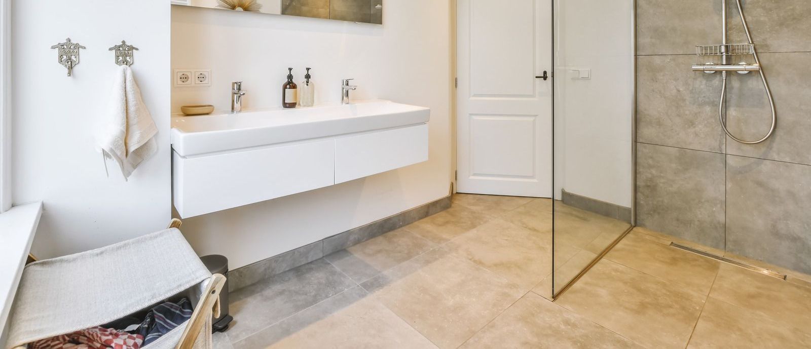 A bathroom with a walk in shower , sink and mirror.