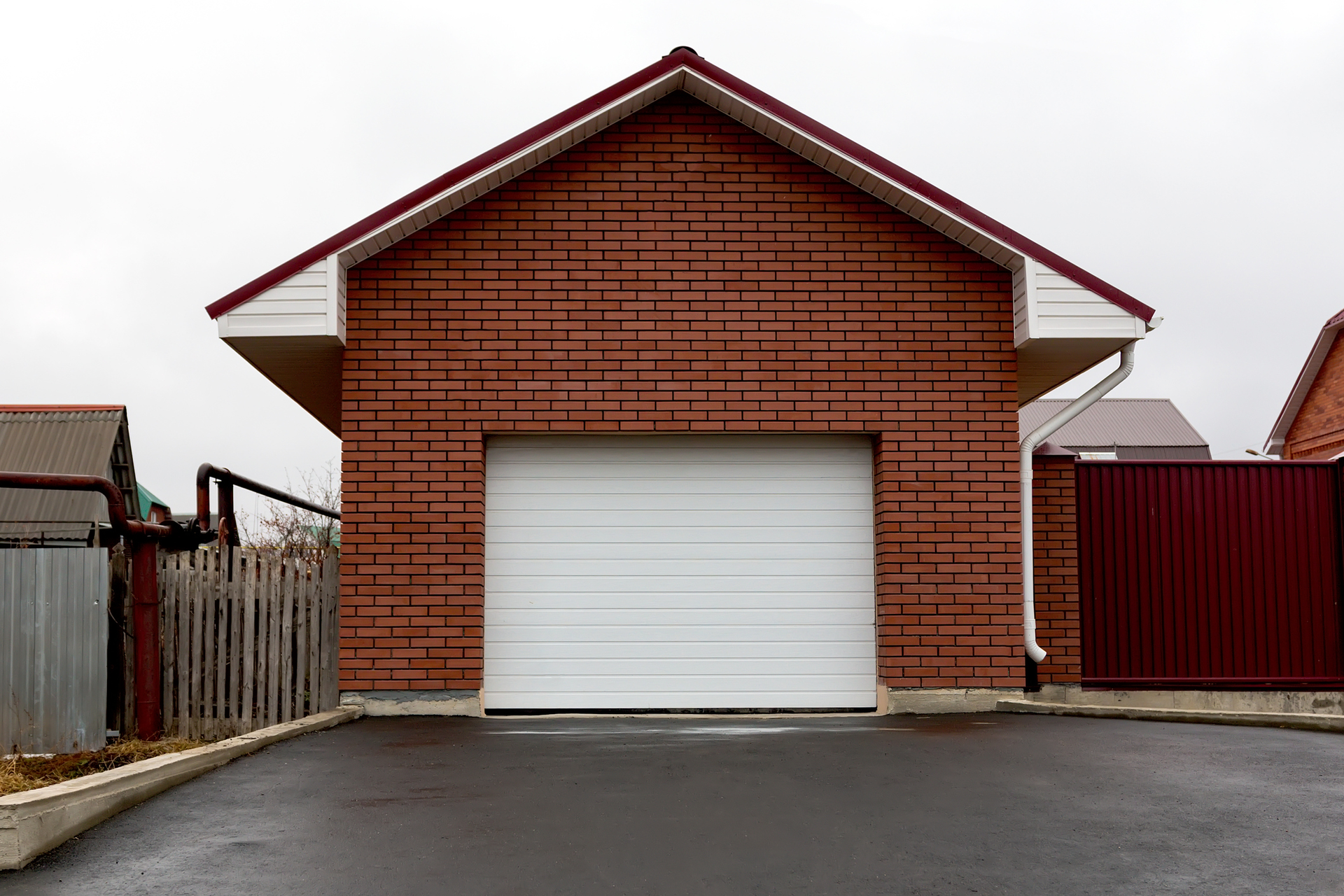 White garage installed at the front of a building with red bricks.