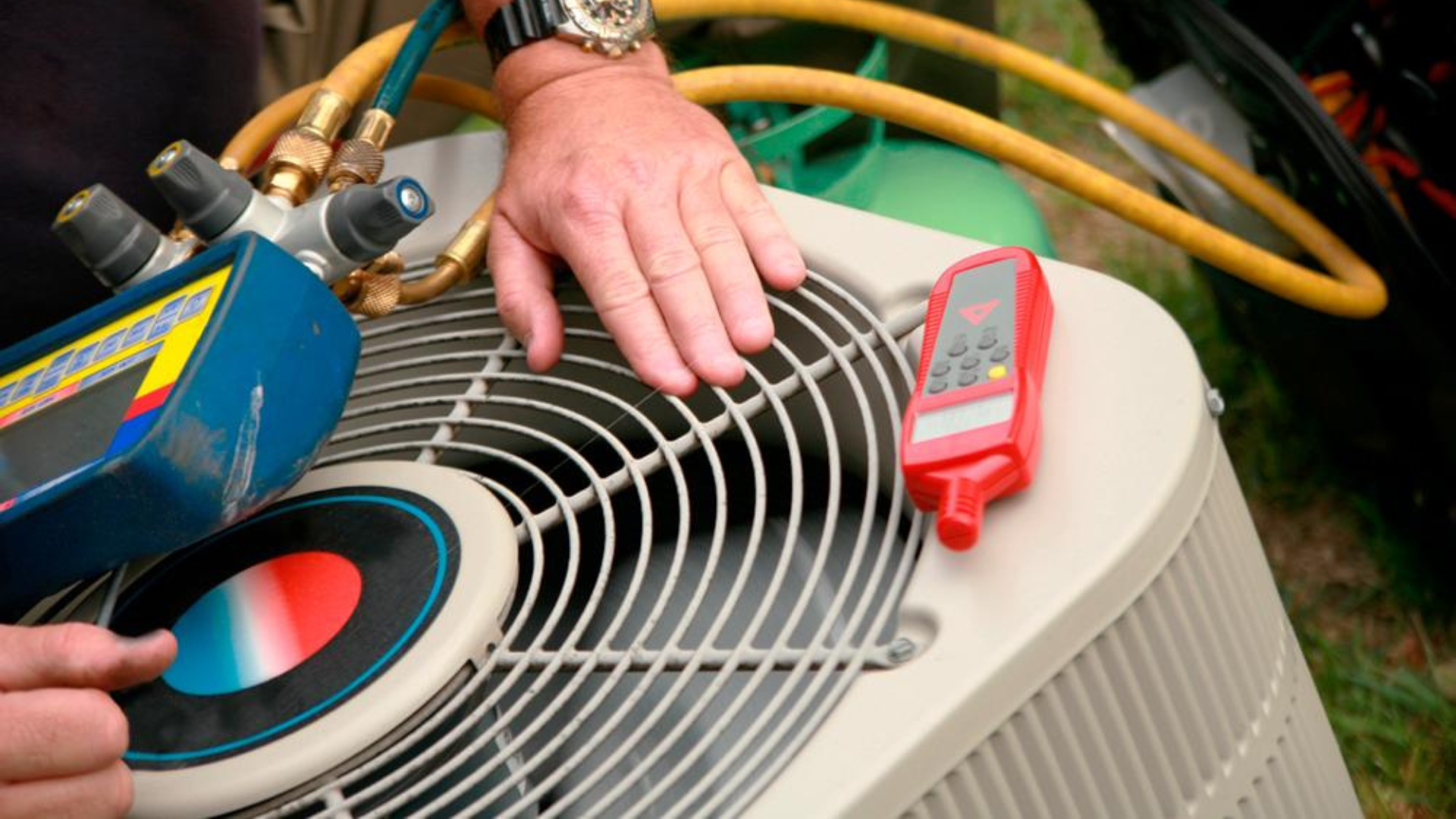 HVAC technician using gauges on an air conditioner unit in an outdoor setting.