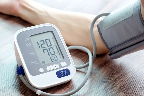 Close-up of a digital blood pressure monitor displaying systolic and diastolic readings.