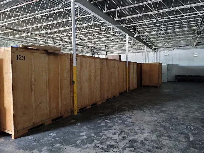 Storage units inside a warehouse. Wooden boxes line the wall, with number 123 visible.
