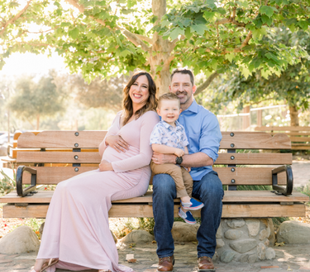 A small family sitting together on a bench captured by shy heart studios photographers