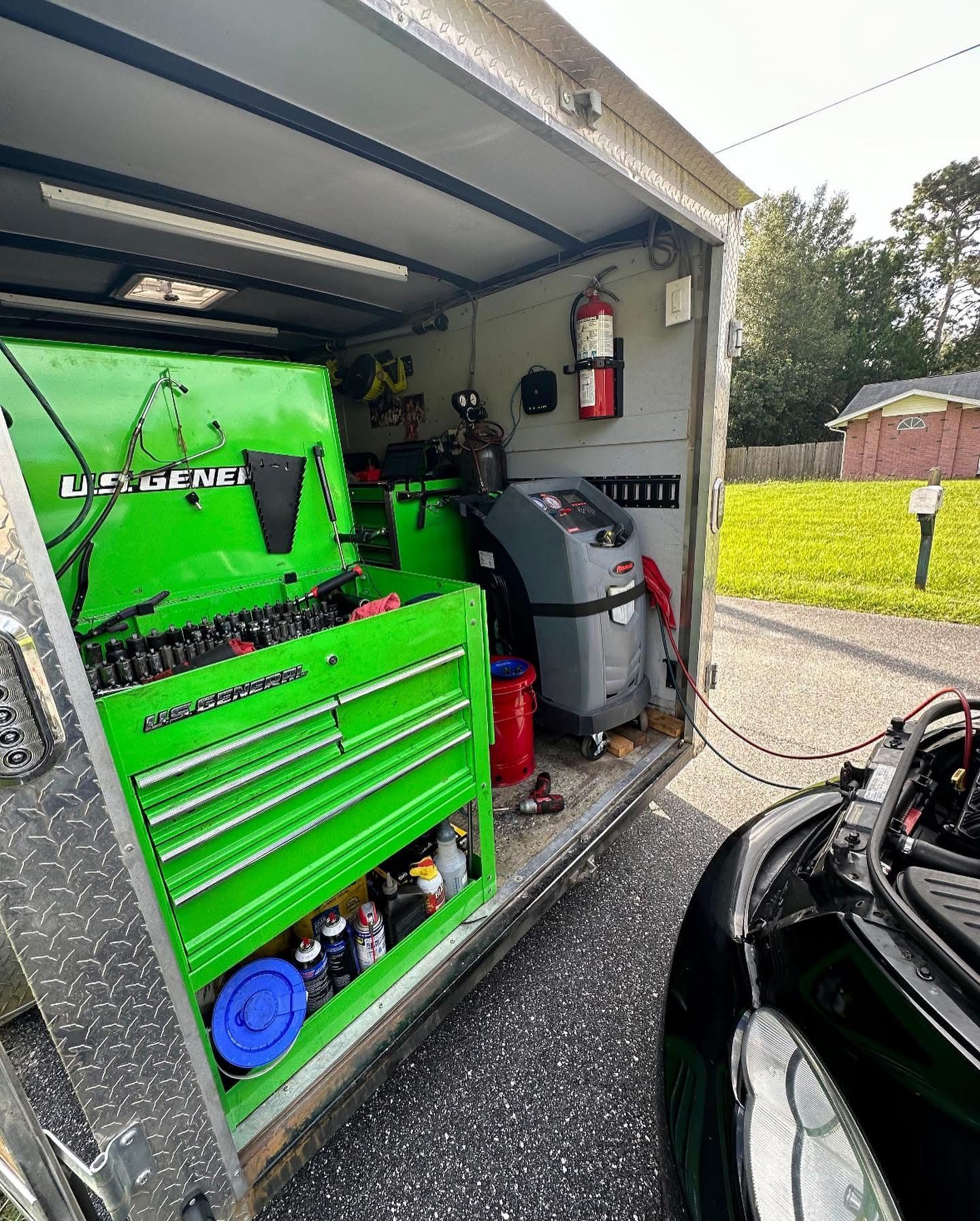 Green tool chest in an open trailer, connected to a car | 3T’s Mobile Automotive Repair Inc.