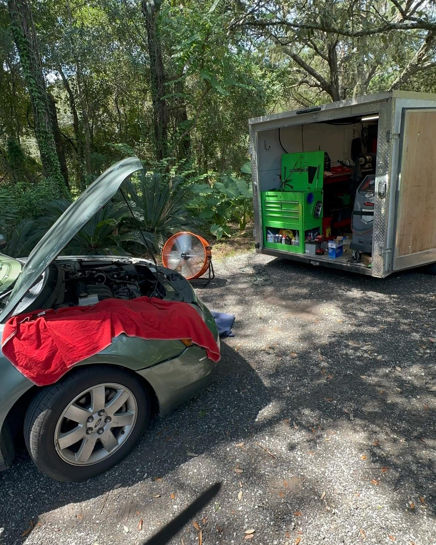 Green car with open hood, tools, and trailer | 3T’s Mobile Automotive Repair Inc.