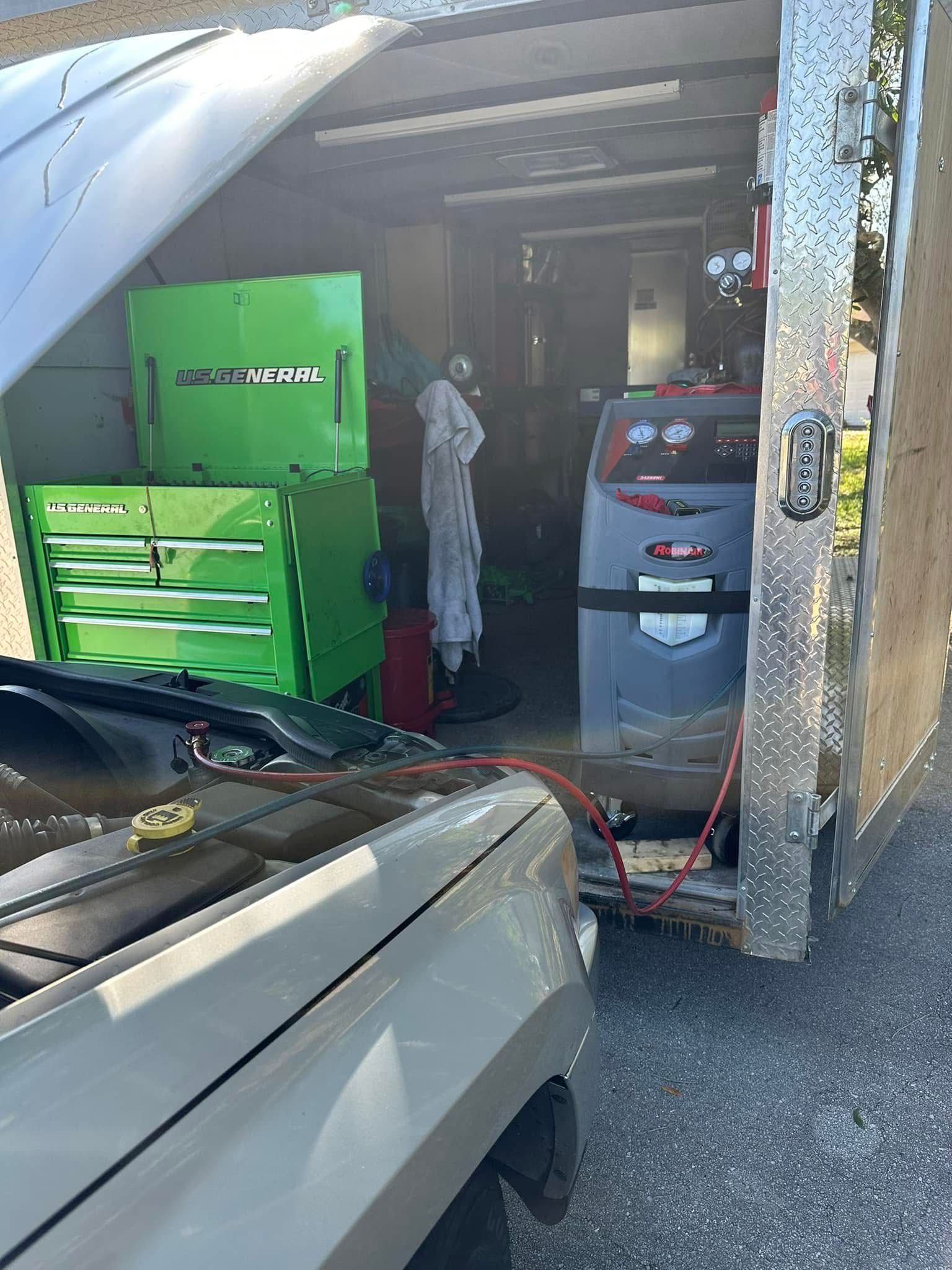 A truck's engine bay connected to diagnostic equipment inside a mobile mechanic's trailer | 3T’s Mobile Automotive Repair Inc.