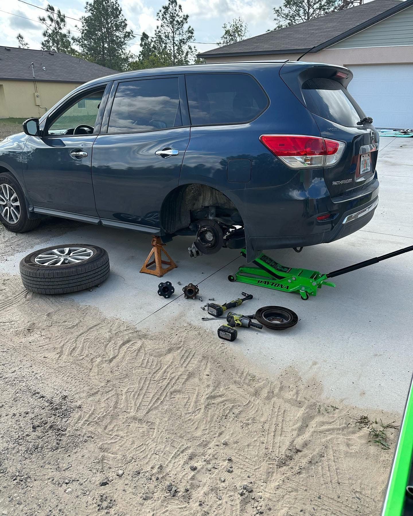 Blue SUV with a tire removed, being worked on outdoors | 3T’s Mobile Automotive Repair Inc.