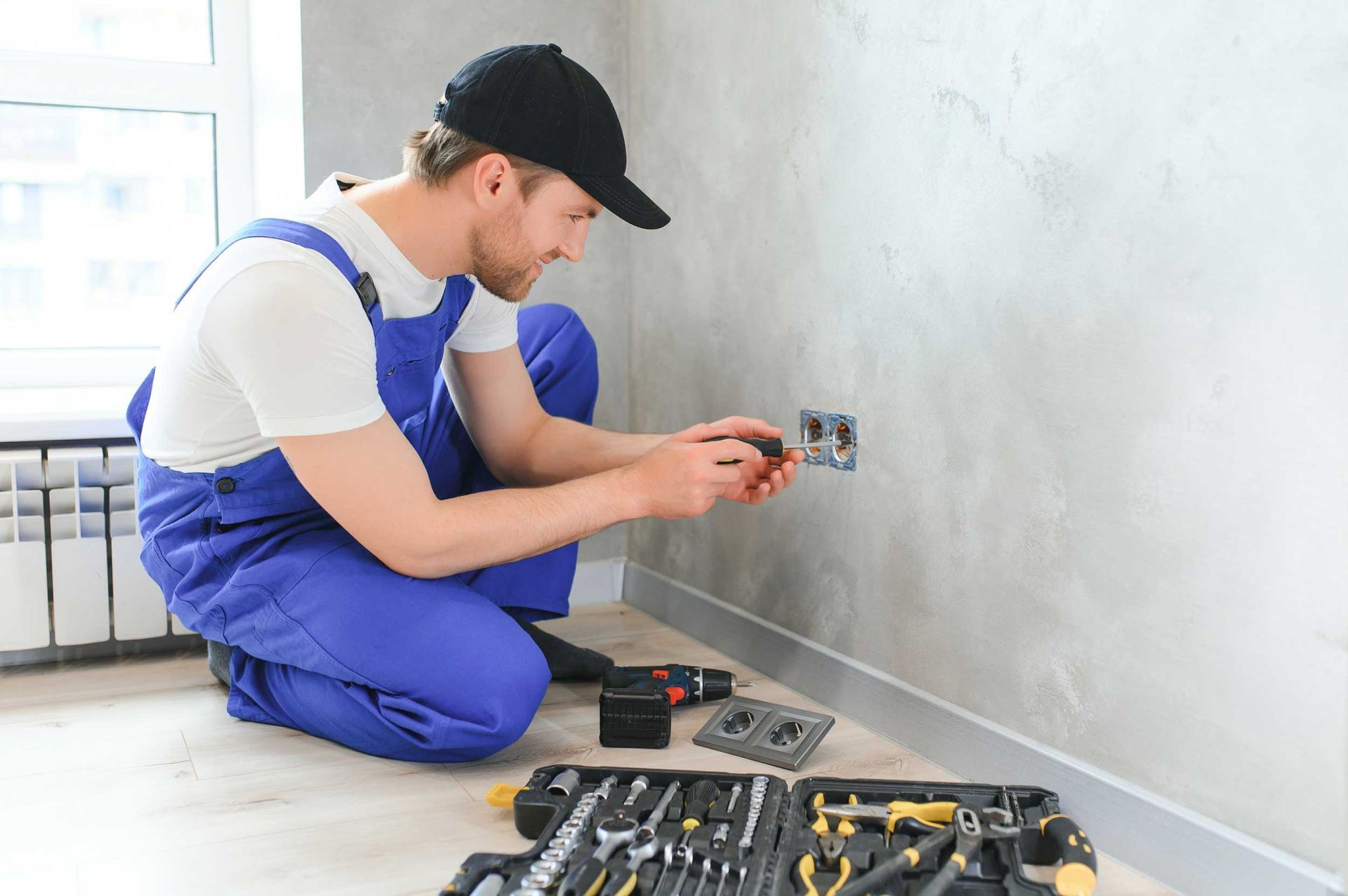 An electrical expert assembles a power point in an apartment.