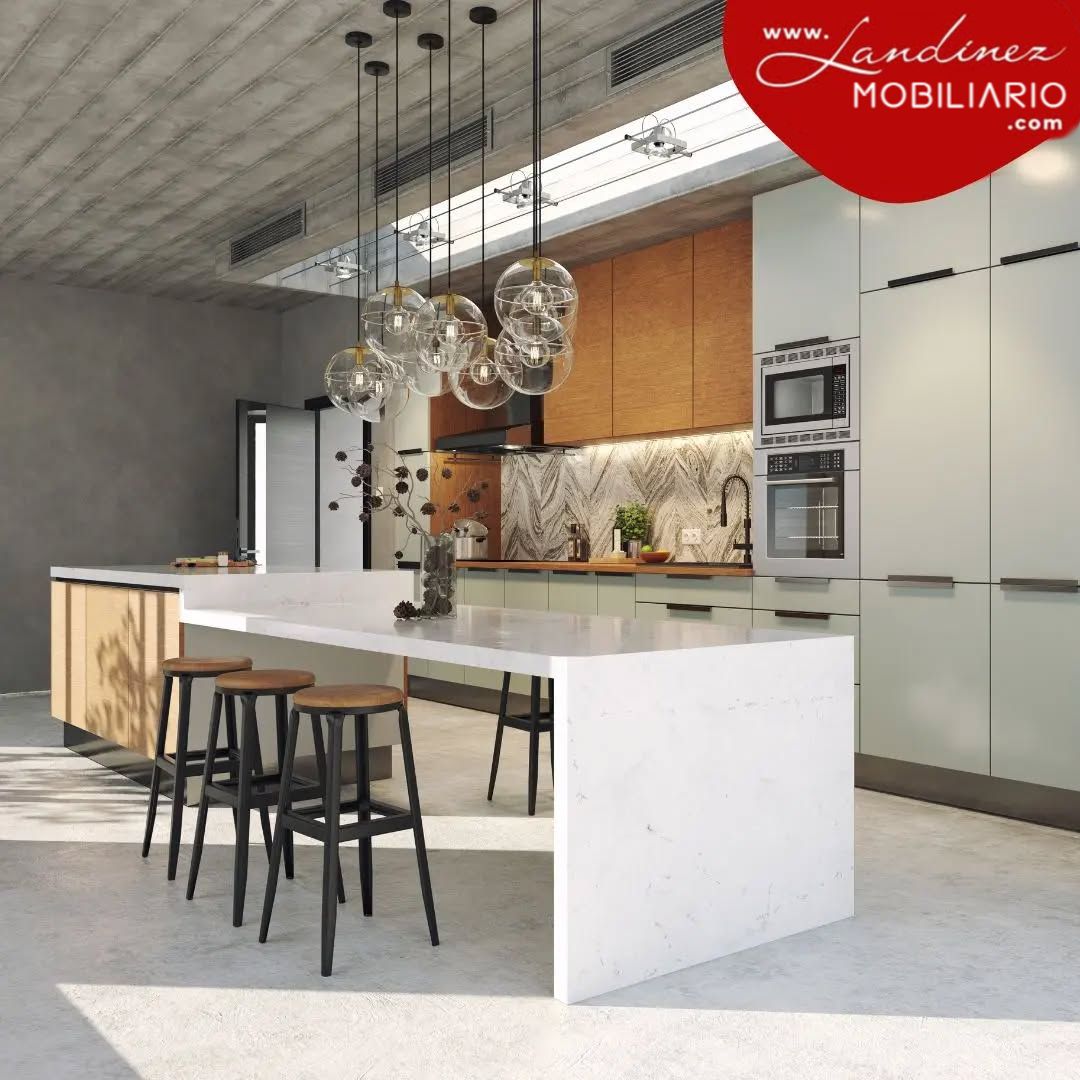 Cocina moderna con isla, taburetes e iluminación cenital.