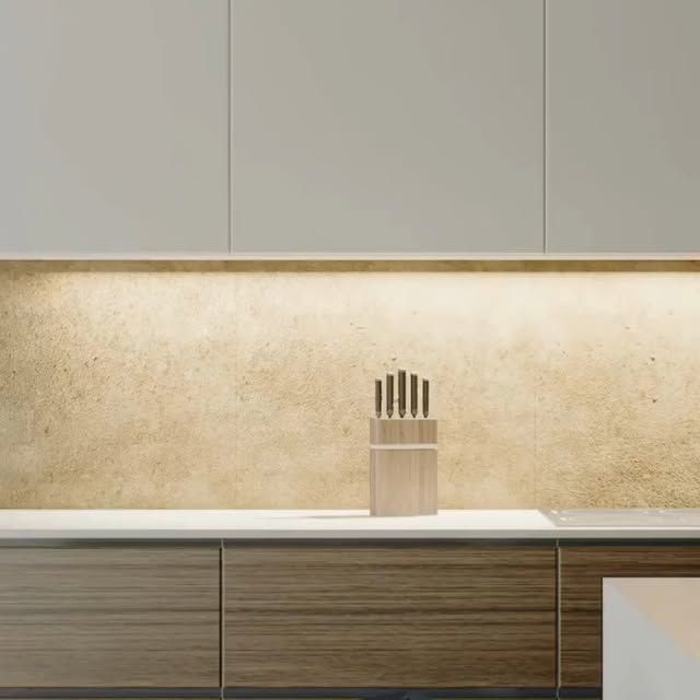 Cocina moderna con gabinetes de madera, protector contra salpicaduras y juego de cuchillos.