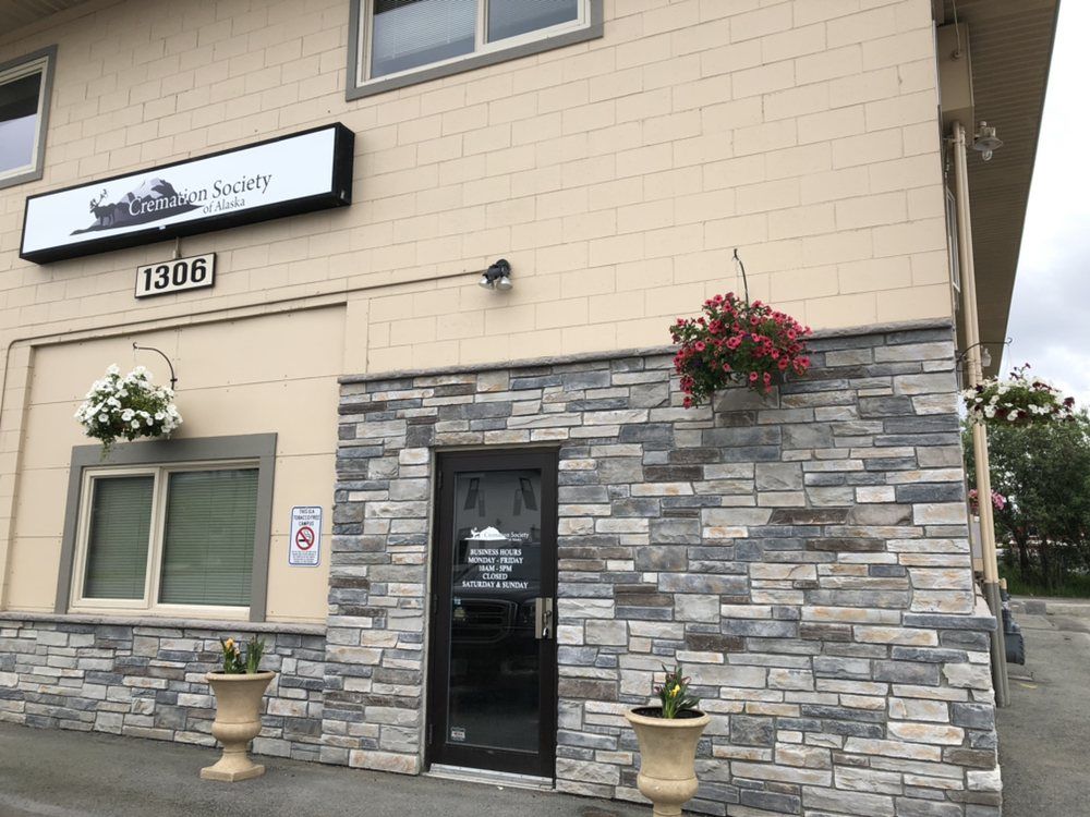 A building located in Anchorage Alaska with a stone facade and a sign that says Cremation Society of Alaska