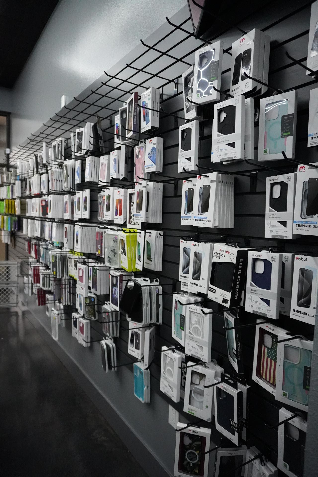 A row of cell phone cases hanging on a wall in a store.