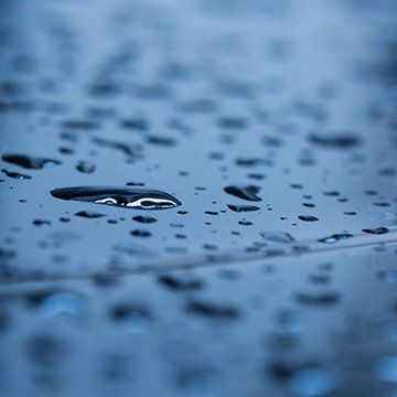 a close up of water drops on a blue surface .