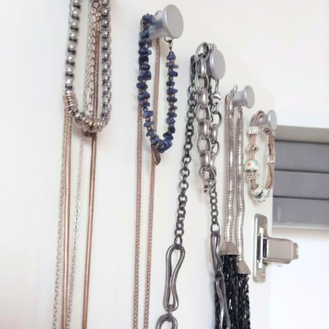 Primer plano de colgantes plateados con collares y  pulseras colgados