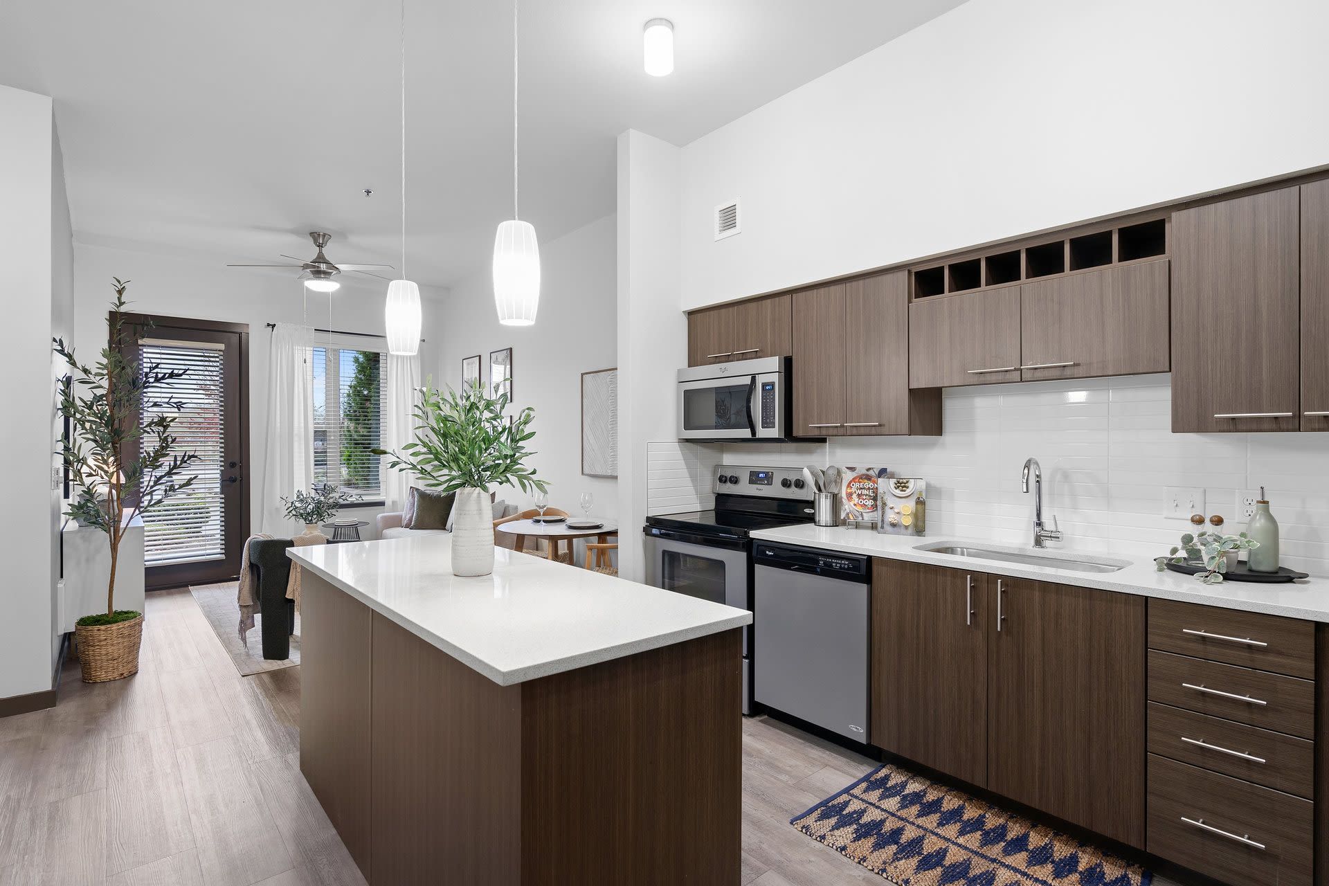 Open-concept kitchen with island, wood-tone cabinets, stainless appliances, and dining area.