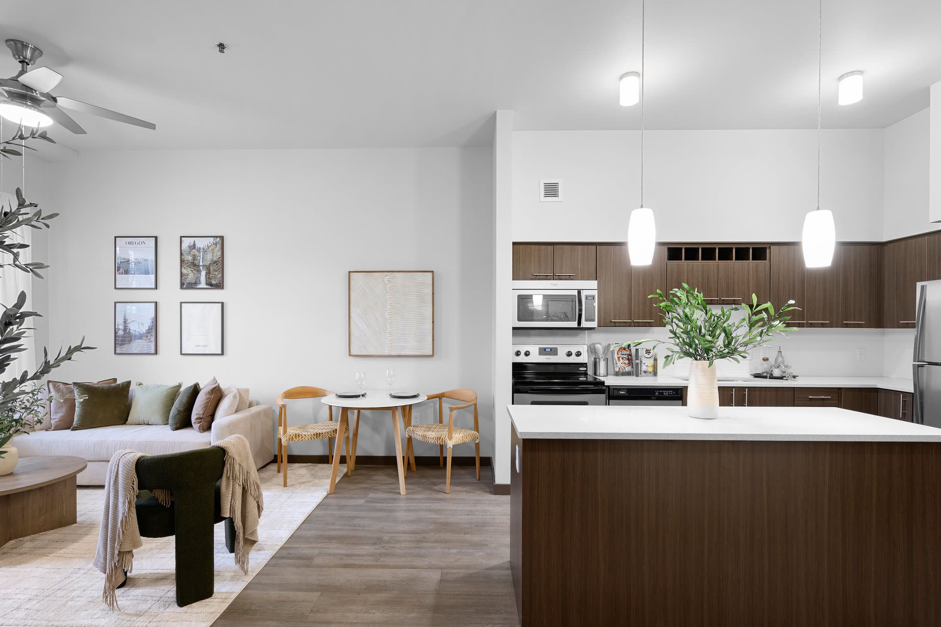 Open-concept living room and kitchen with wood cabinets, island, and neutral decor.