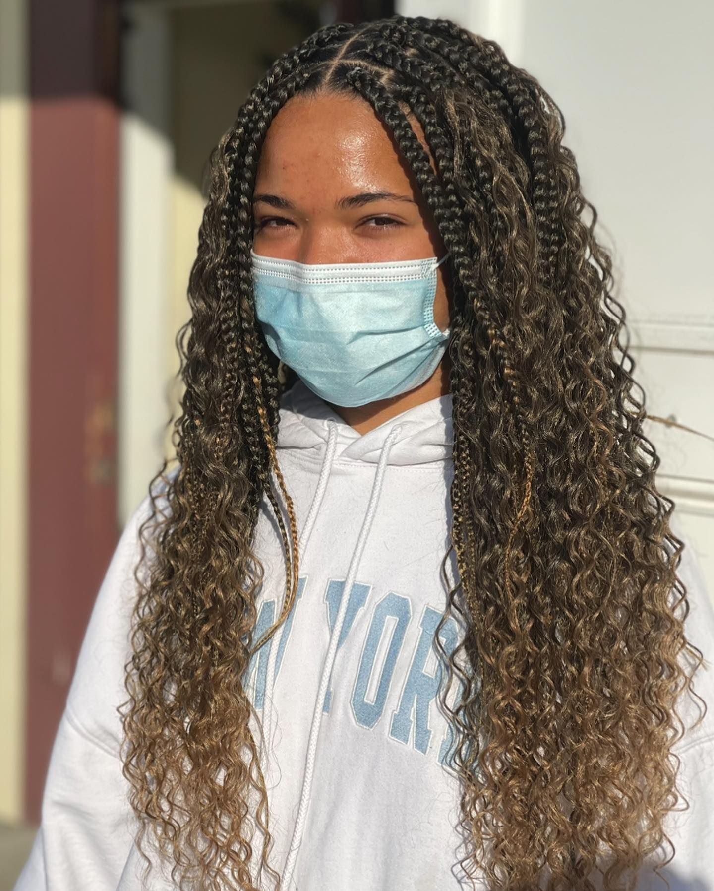 A woman wearing a mask and a hoodie with the word york on it.