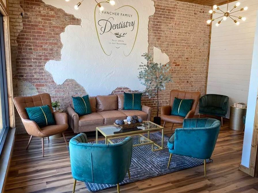 A living room with a couch , chairs , and a coffee table.