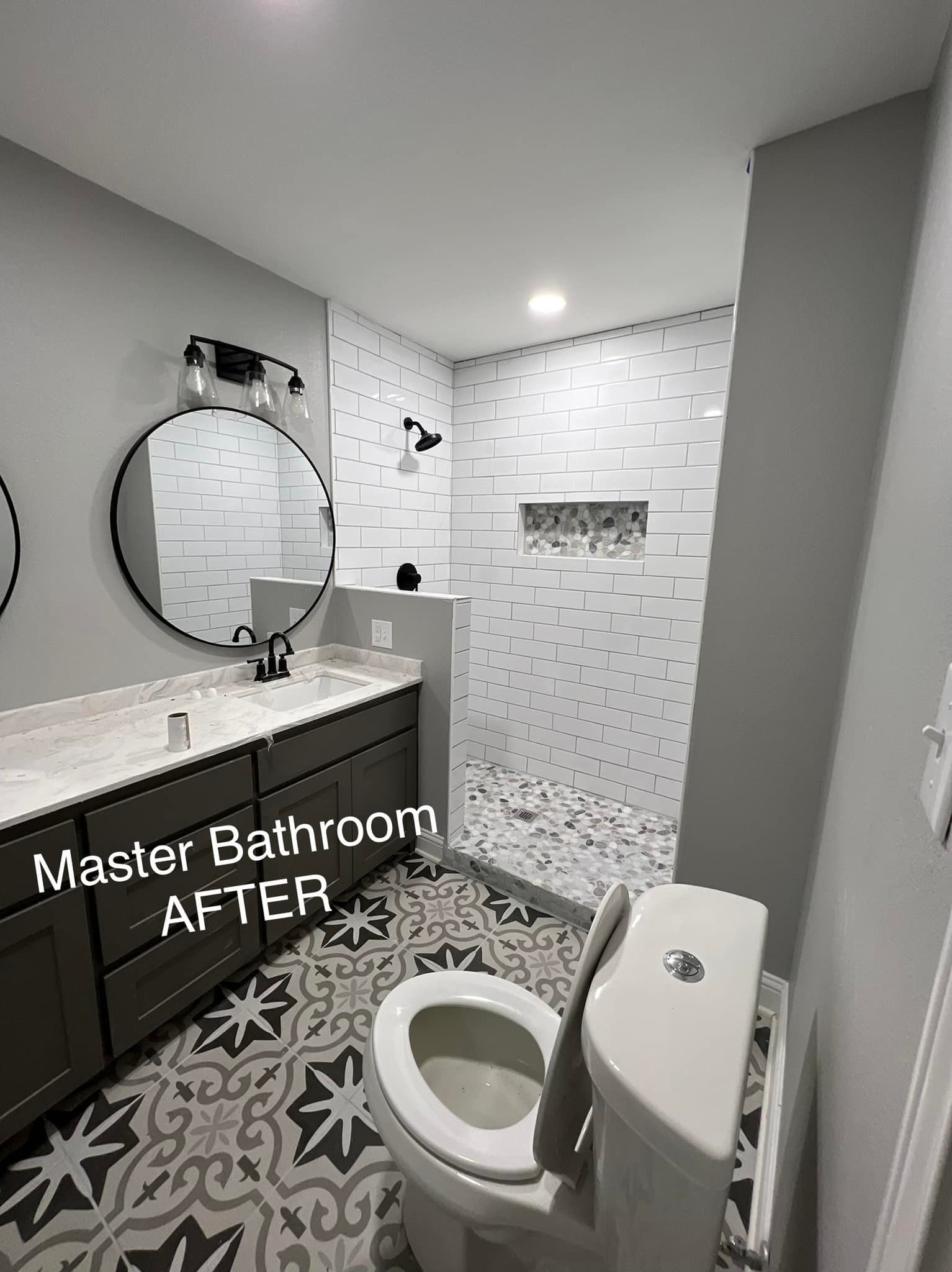 A bathroom with a toilet , sink , mirror and shower.