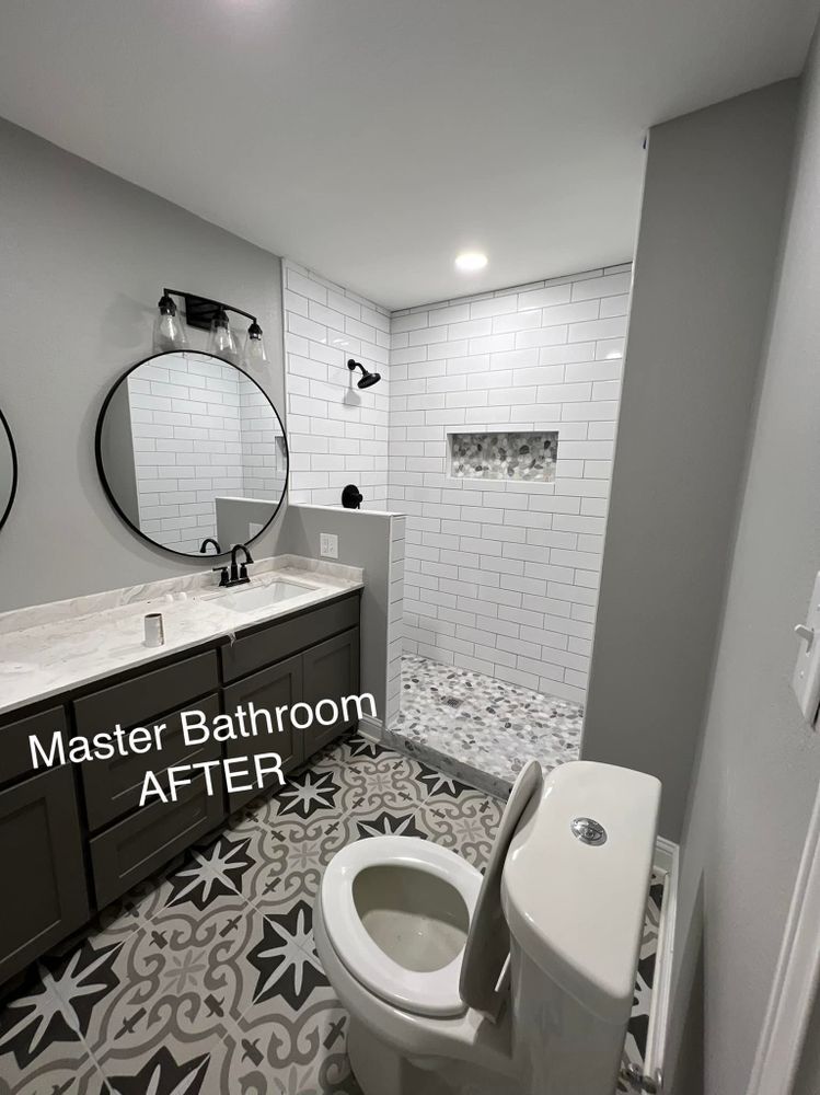 A bathroom with a toilet , sink , mirror and shower.