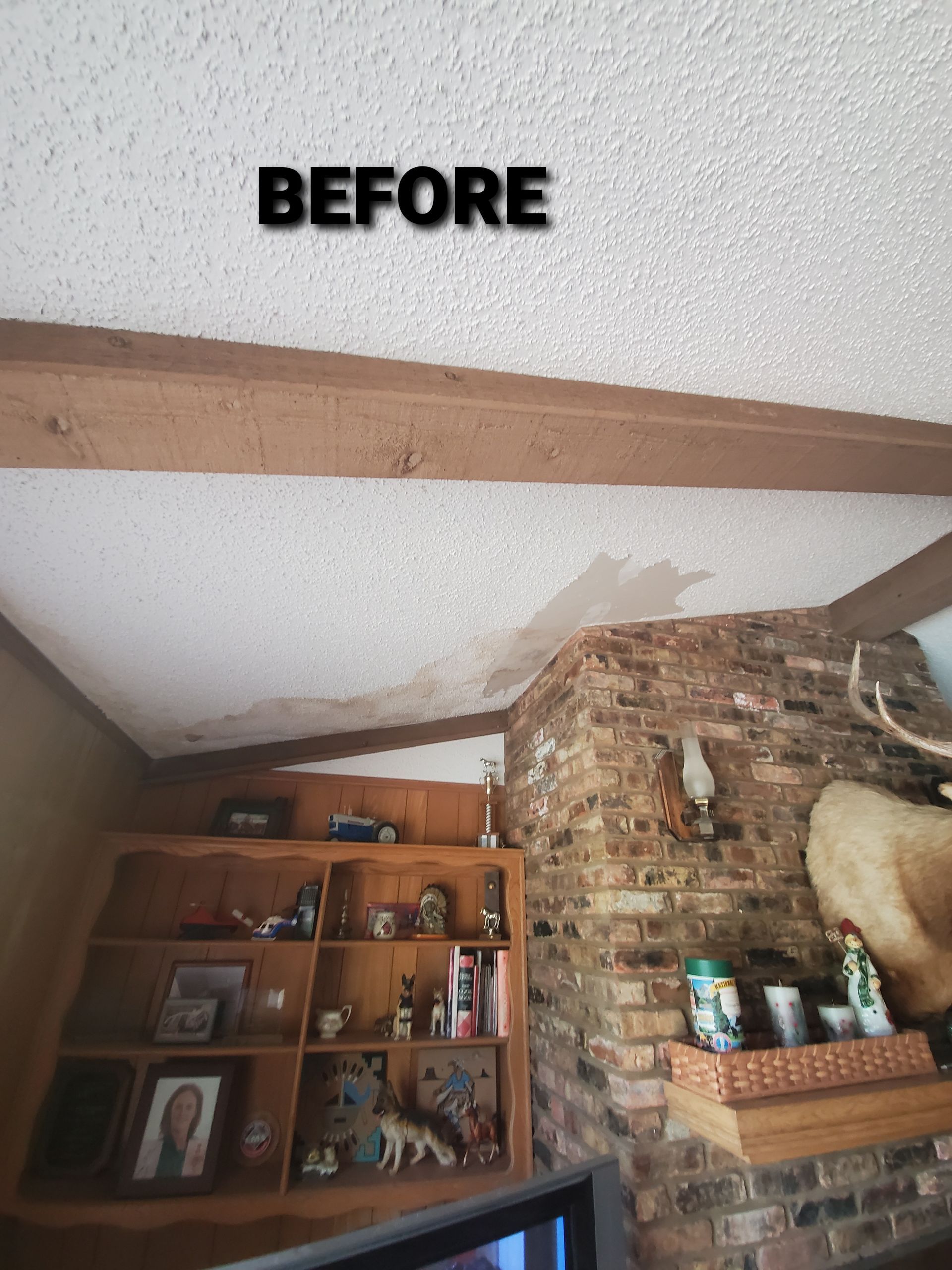 A before picture of a living room with a brick fireplace