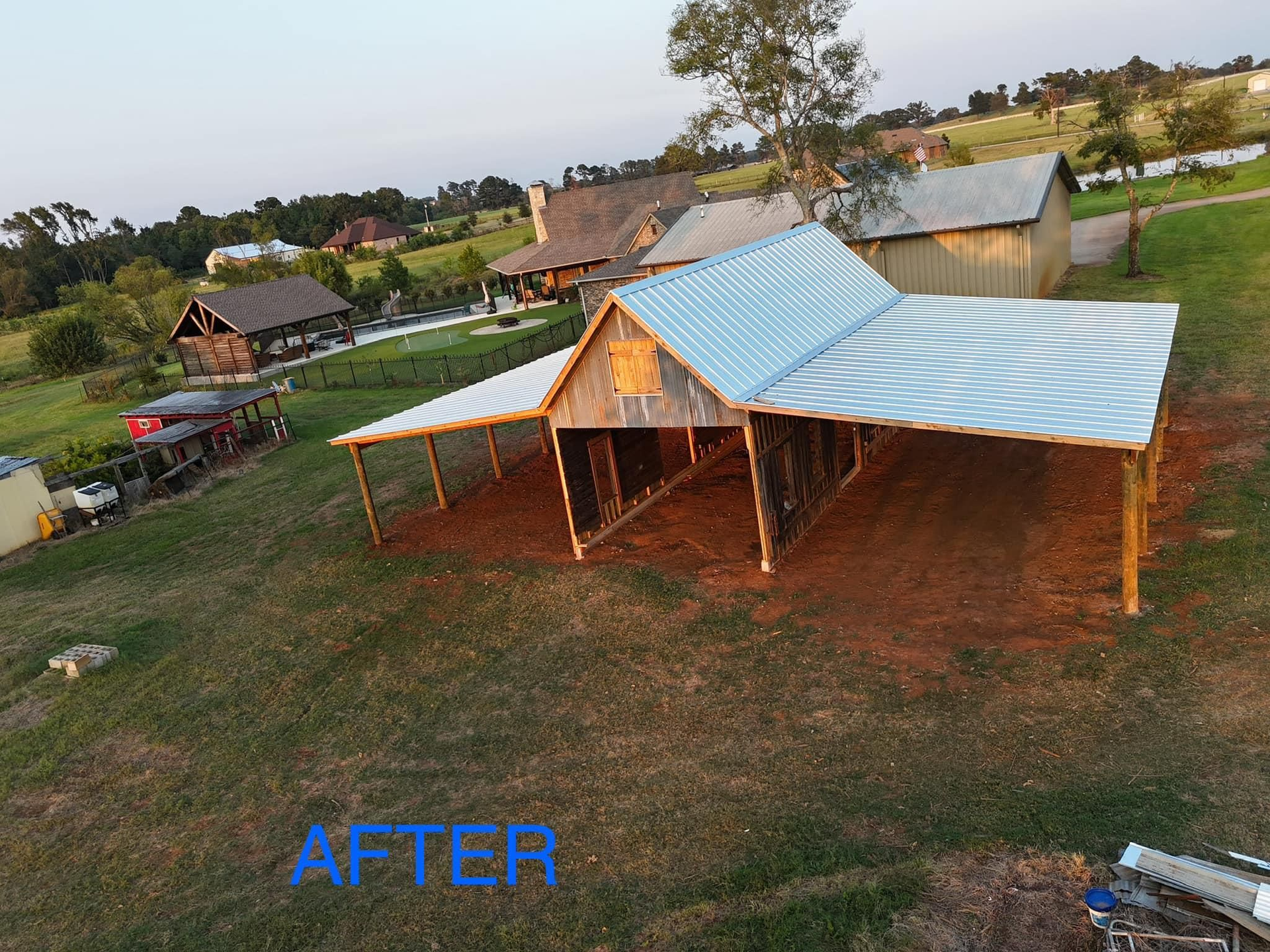 An aerial view of a barn with a metal roof