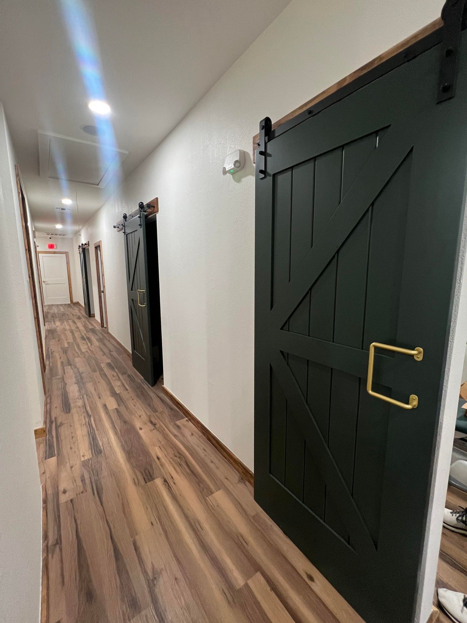 A long hallway with wooden floors and sliding barn doors.