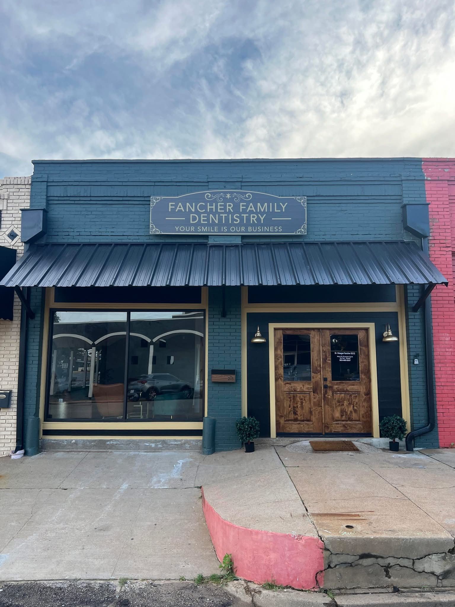 The front of a building with a sign that says ' dentist ' on it