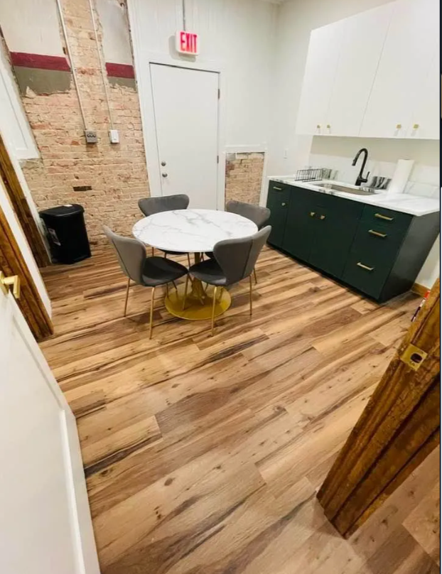 A kitchen with a round table and chairs and a sink