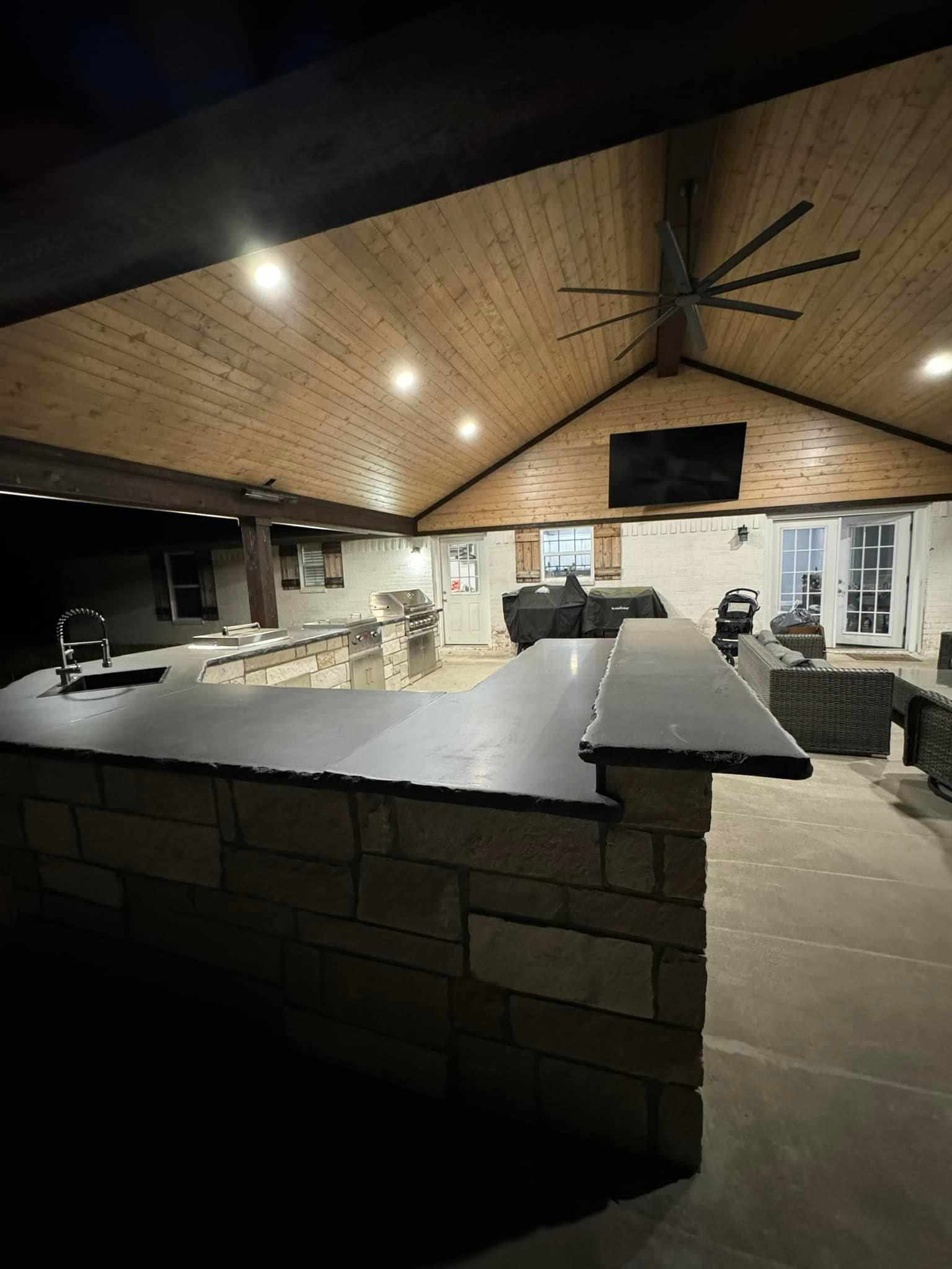 A large room with a ceiling fan and a television on the wall.