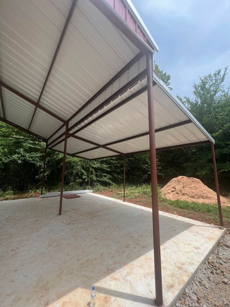A metal carport with a white roof is sitting on top of a concrete driveway.