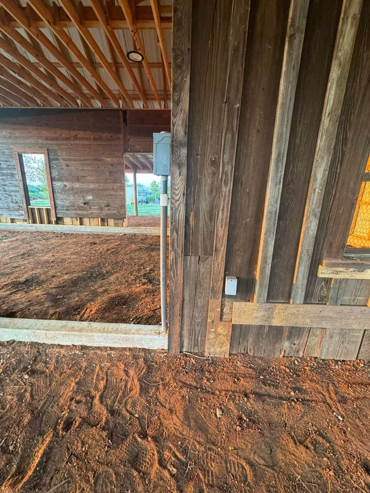 A wooden building under construction with a lot of dirt on the ground.