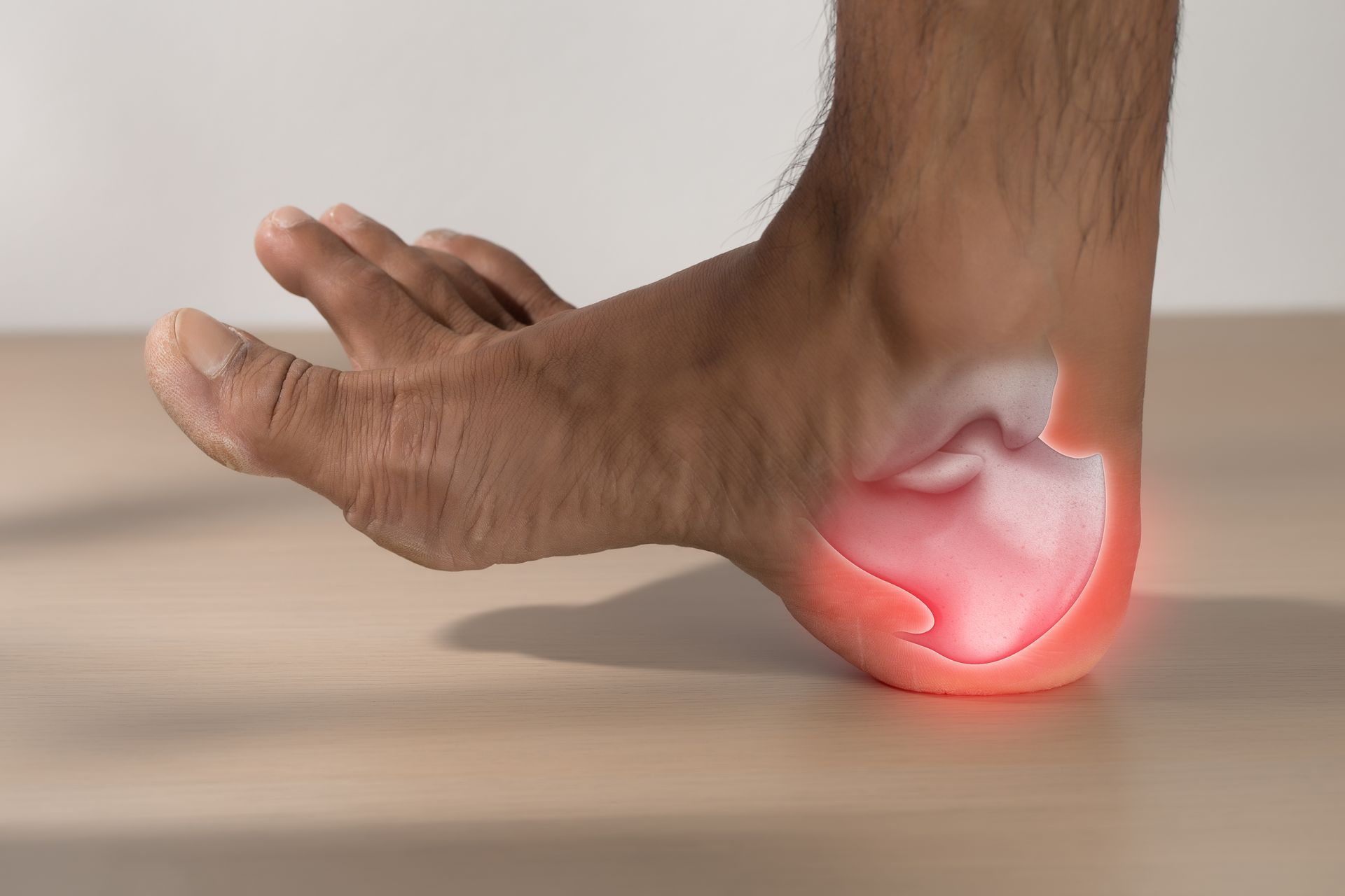 Foot with highlighted red area on heel, indicating pain.