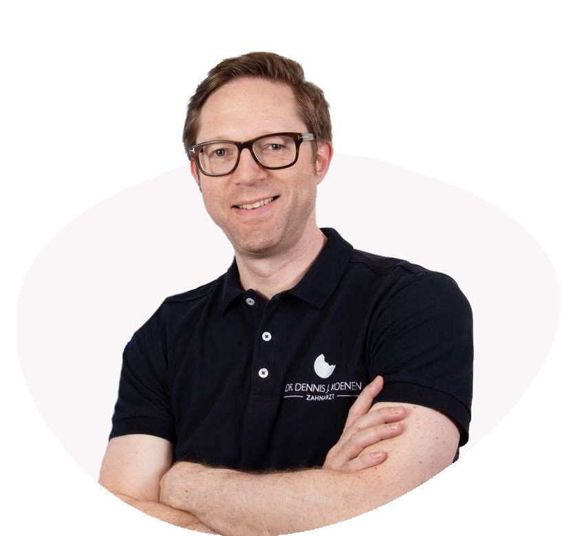 Ein Mann mit Brille und schwarzem Poloshirt lächelt und verschränkt die Arme.