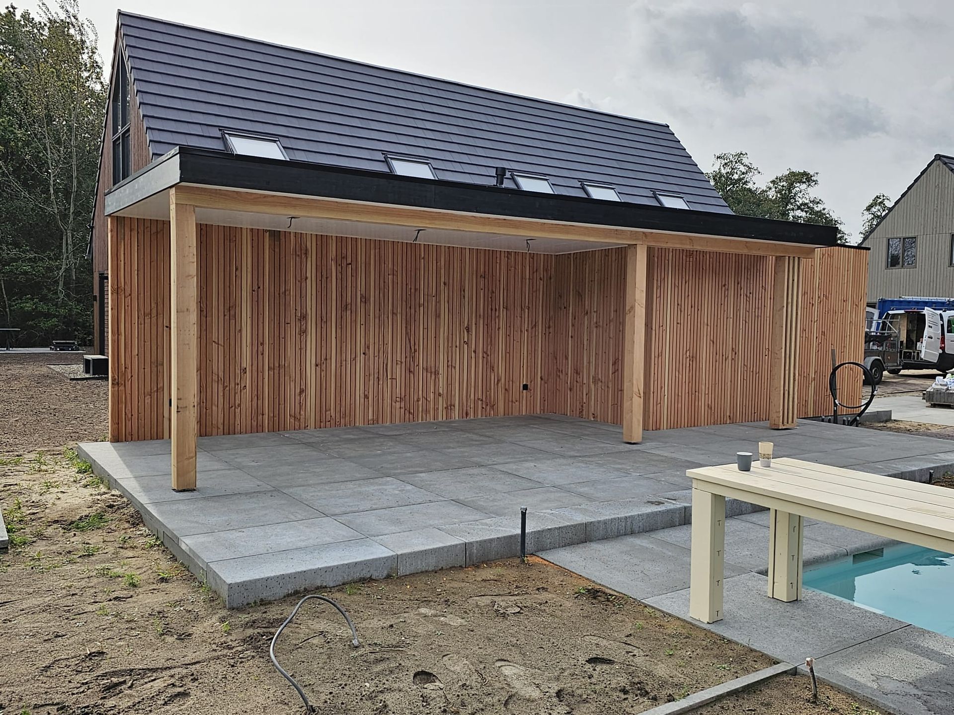 Losse douglas overkapping met verticaal geplaatste lariks latten.